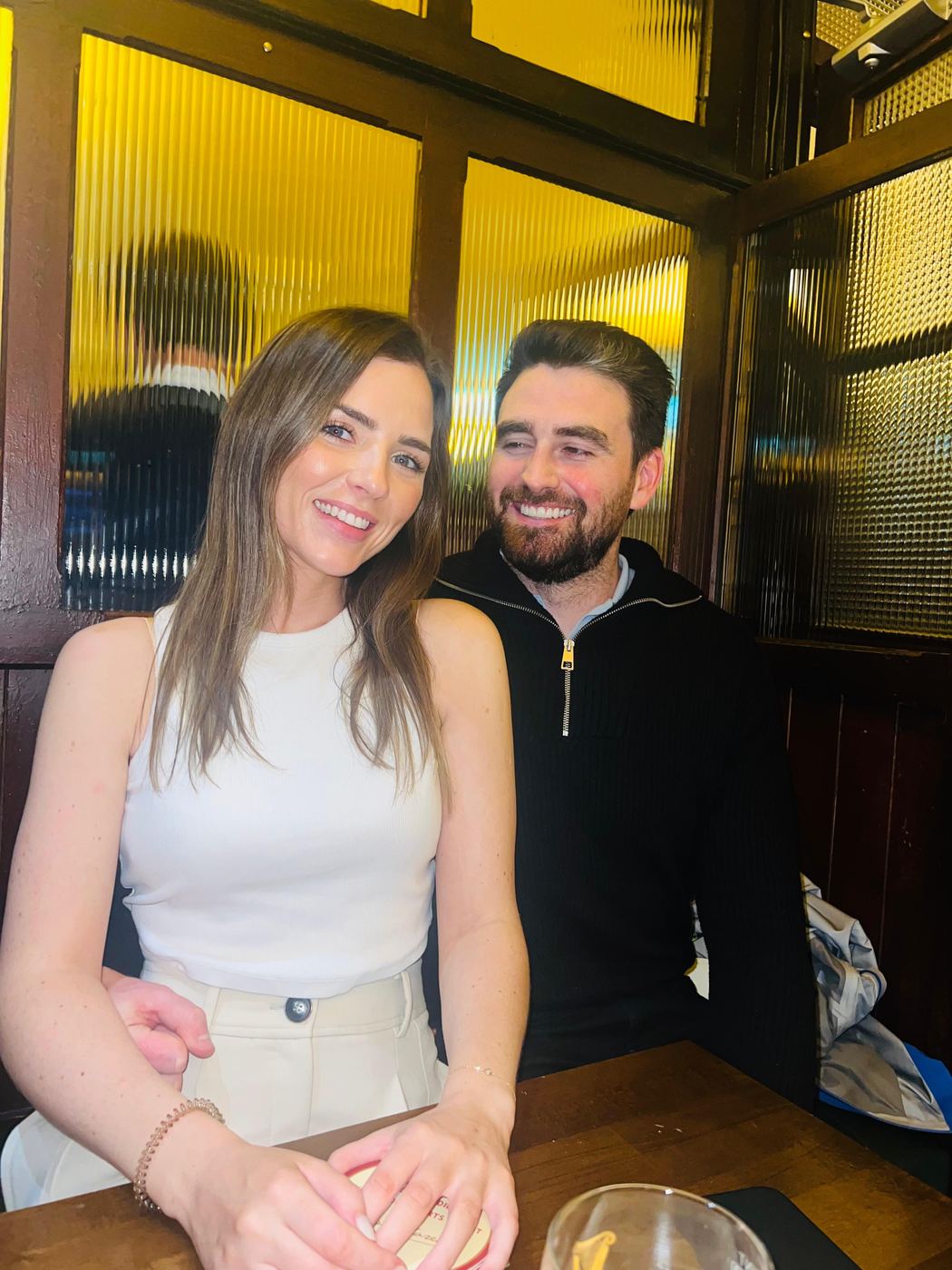 Niamh and Jack smiling together at a pub table